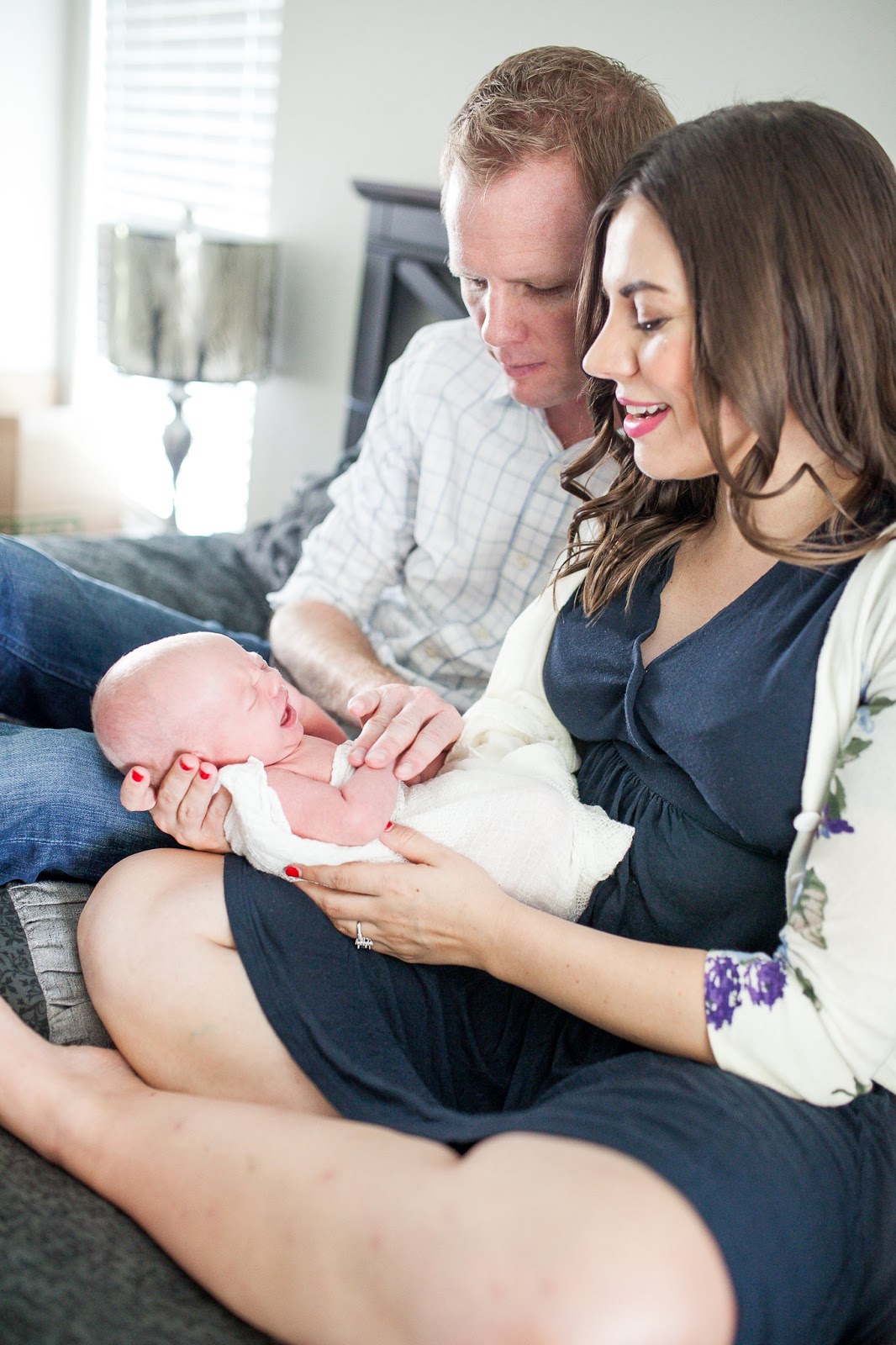 Newborn baby crying while mom and dad try to soothe him. 