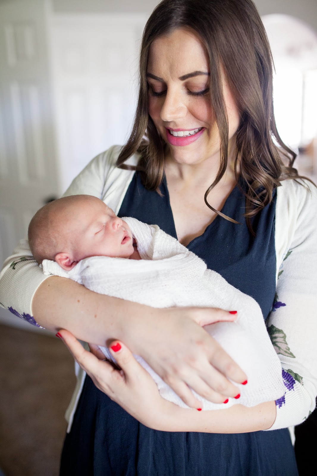 New mom holding her swaddled newborn baby. 