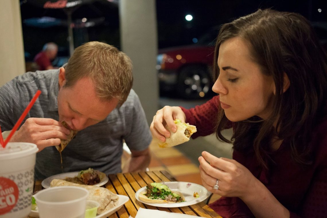 Couple on a date night to eat tacos. 