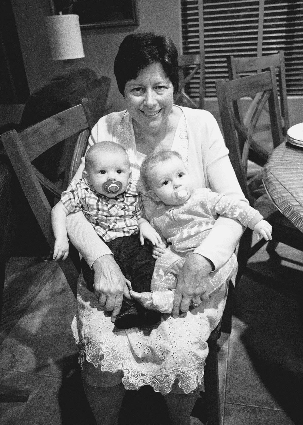 Cute Grandma holding two babies in her lap. 