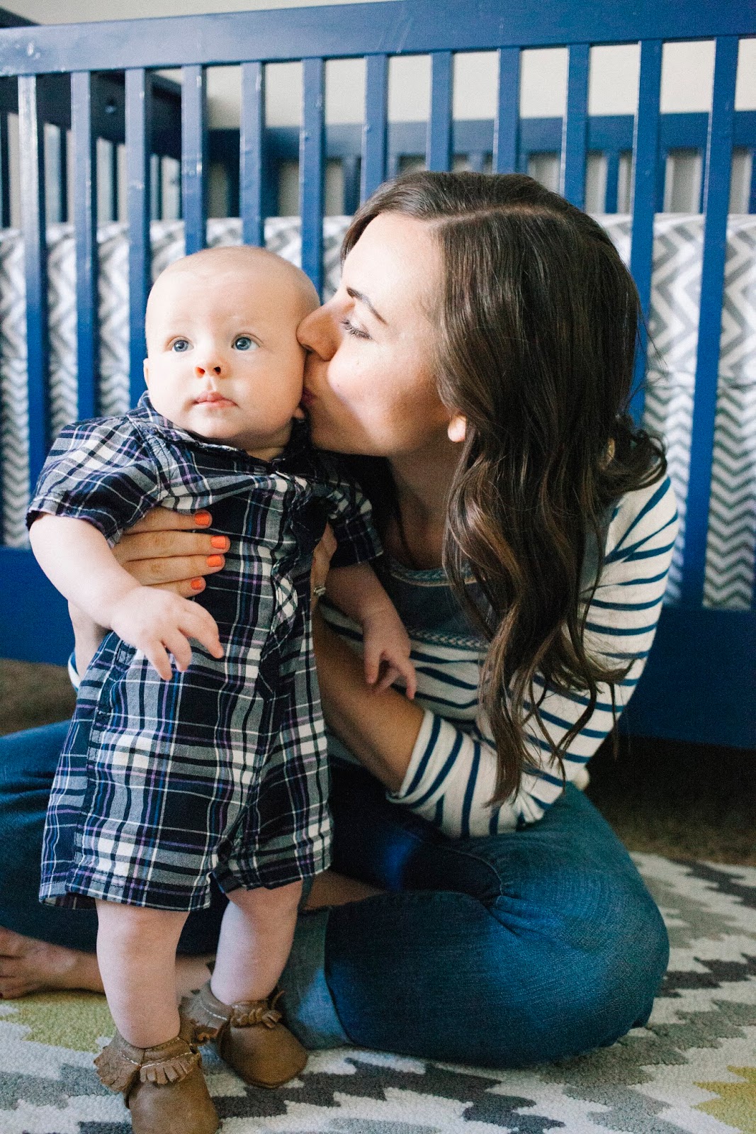 Mom kissing baby on the cheek. 