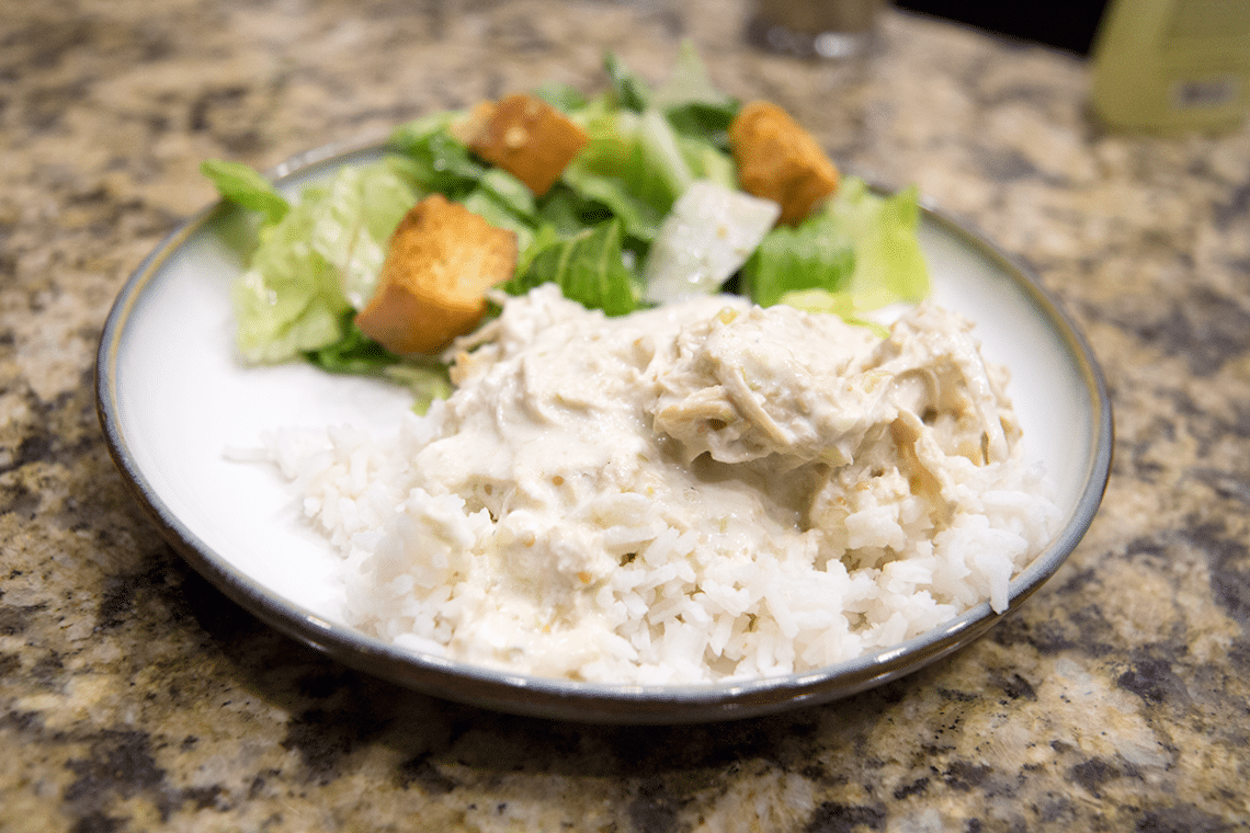 Creamy salsa verde chicken served over rice and a side salad. 
