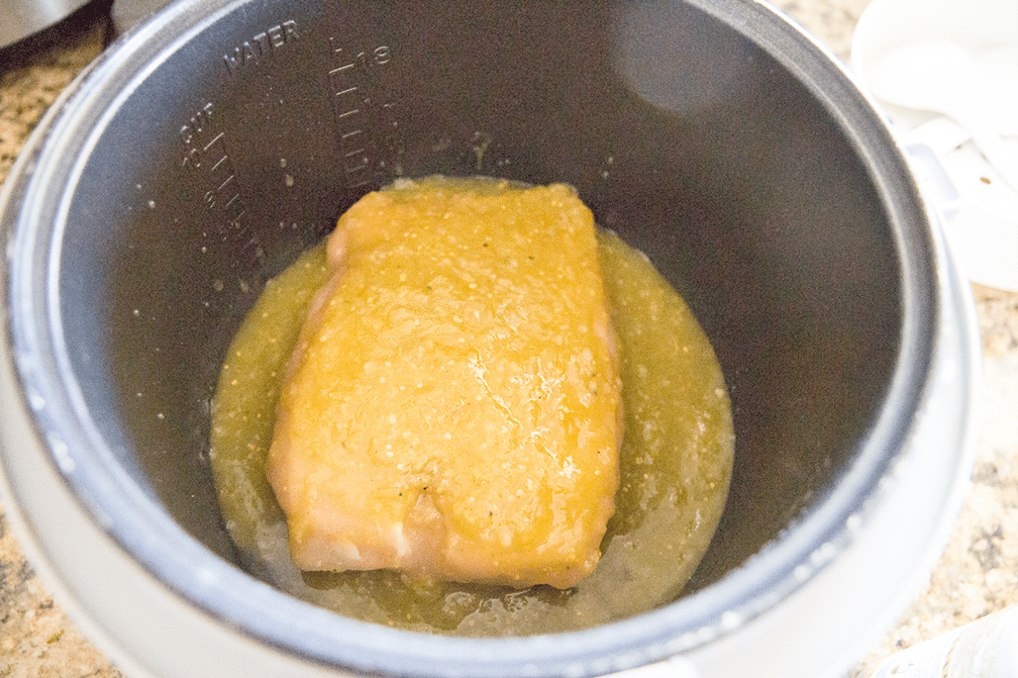 Process shot preparing creamy salsa verde chicken in the crock pot. 