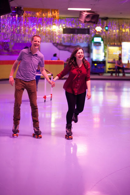 Couple holding hands on a roller skating date night while skating around the rink. 