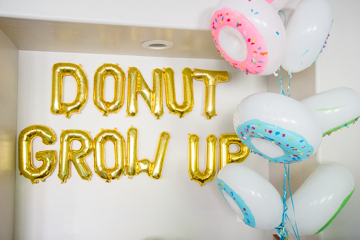 Donut Grow Up balloons on wall. 