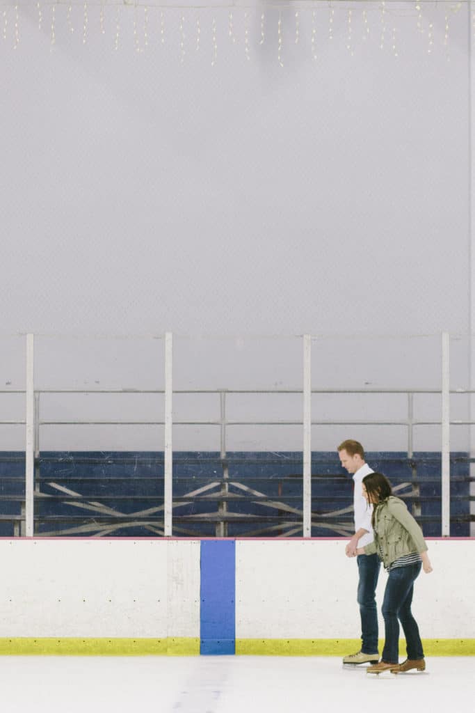 Couple holding hands on the ice during an Ice Skate Date. 