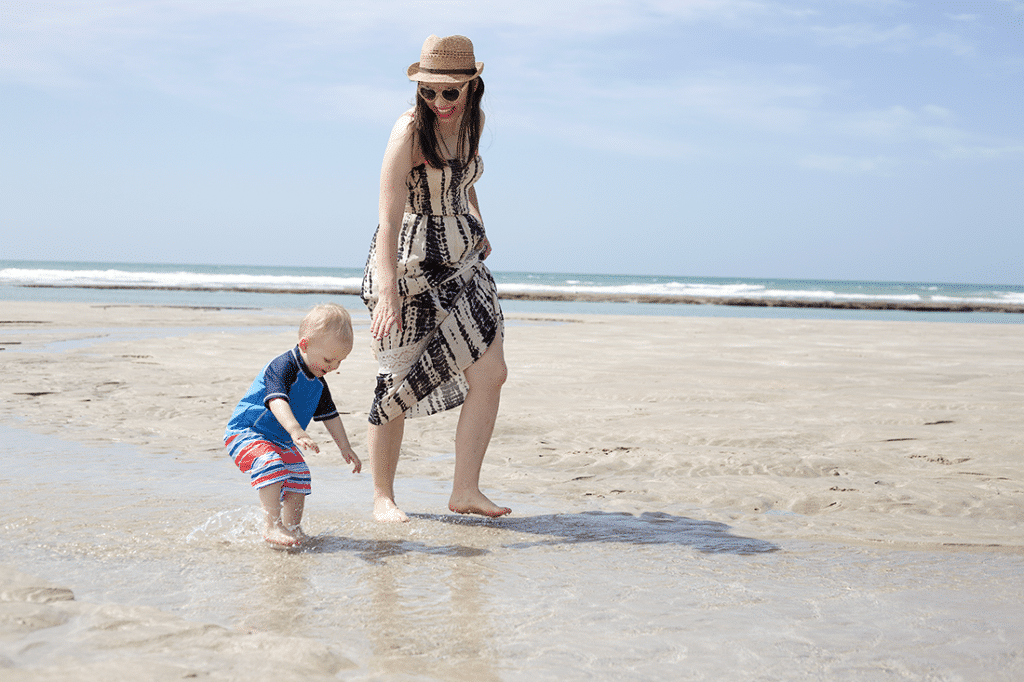 Mom and toddler playing at the beach. 