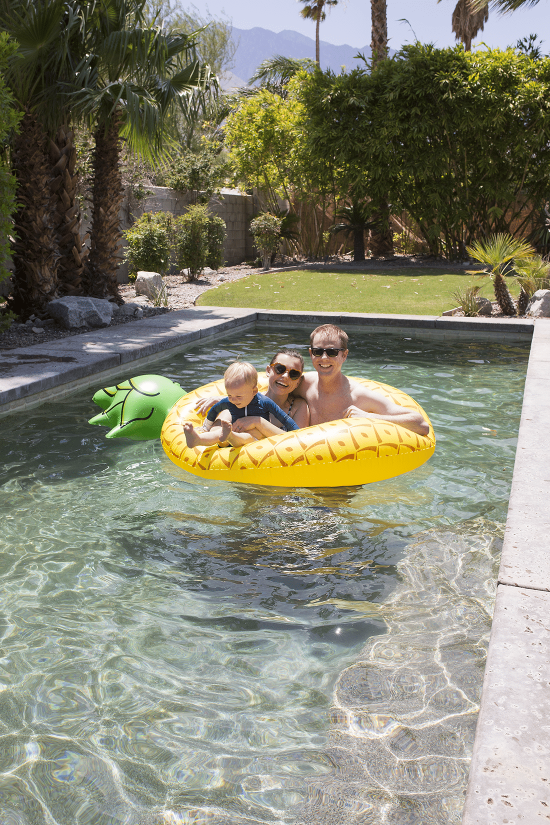 Family swimming in a pool. Fitting Summertime Fun as a family into your budget. 