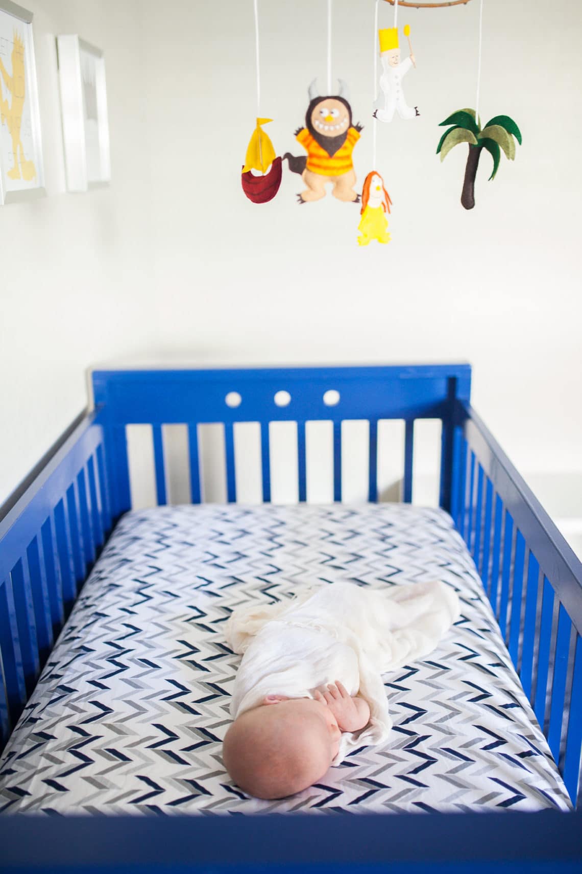 A blue statement crib in a baby nursery. 