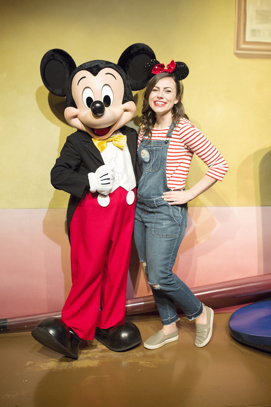 Woman with Mickey Mouse sharing what to wear to Disneyland. 