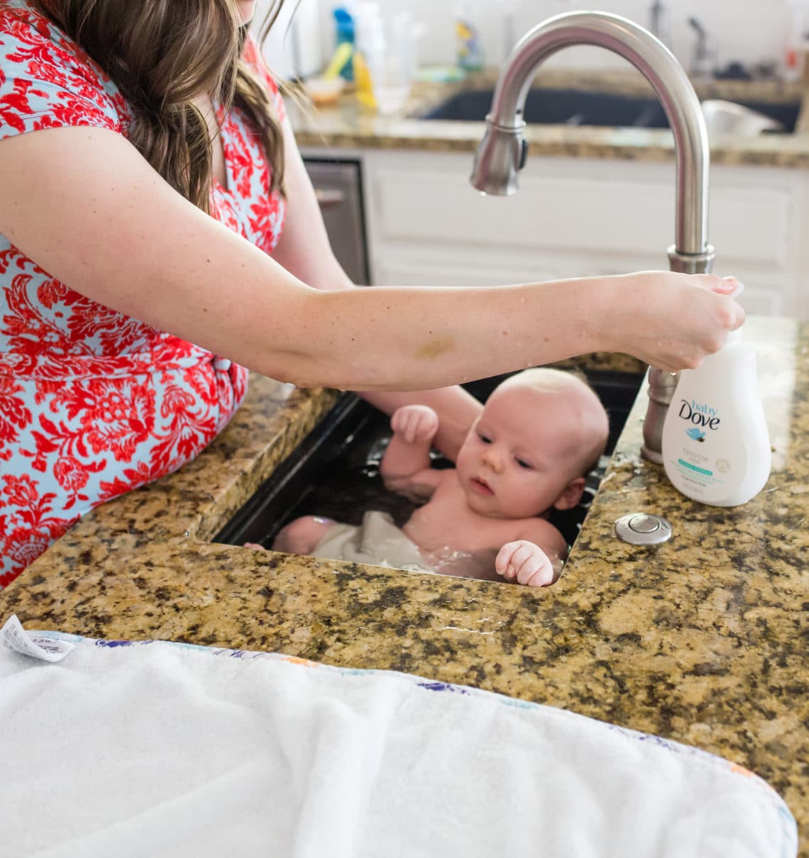 Bathing a baby in a sink to help them calm down. 