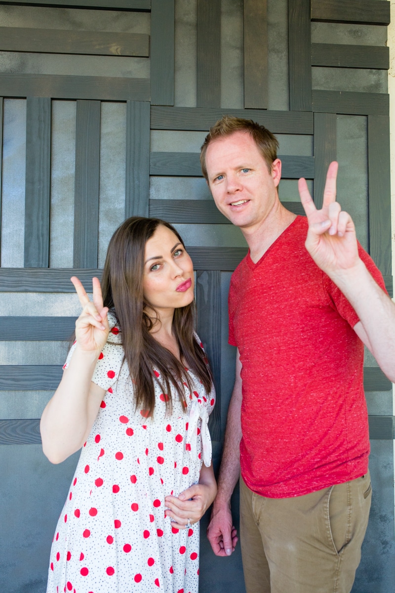 Couple in front of plank accent wall. 