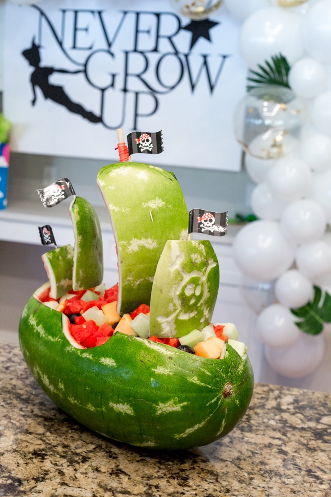 Peter Pan Birthday Party with a watermelon carved into a pirate ship full of fruit salad. 