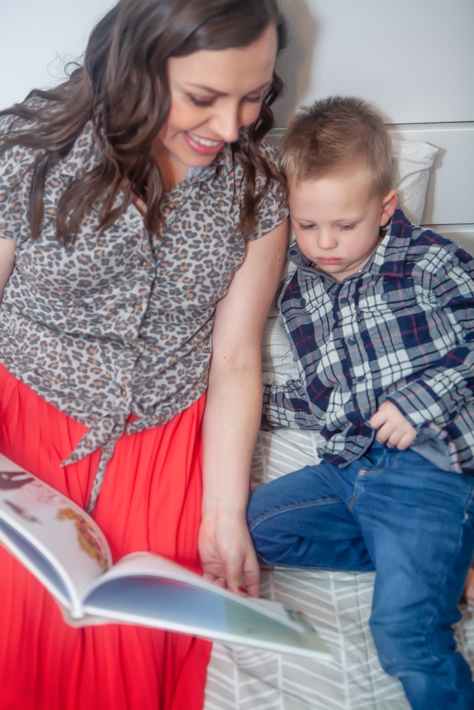 Mom reading book to her son. 