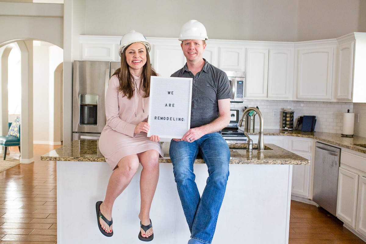 We're Remodeling couple holding a sign. 