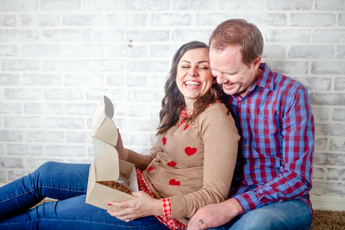 A husband and wife exploring Stay At Home Date Ideas inside a date night box. 