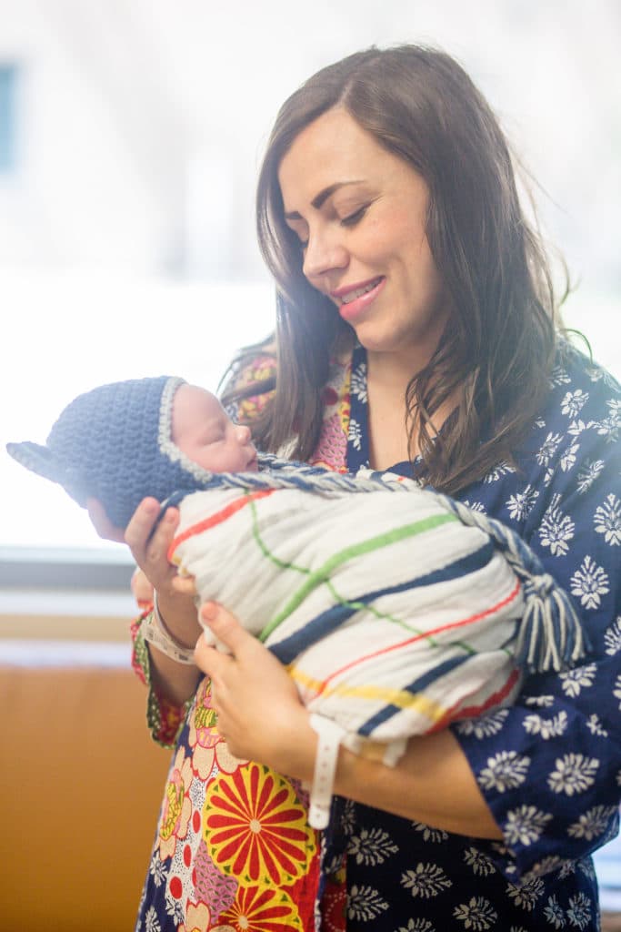 Mom holding a newborn with tips to help new mothers. 