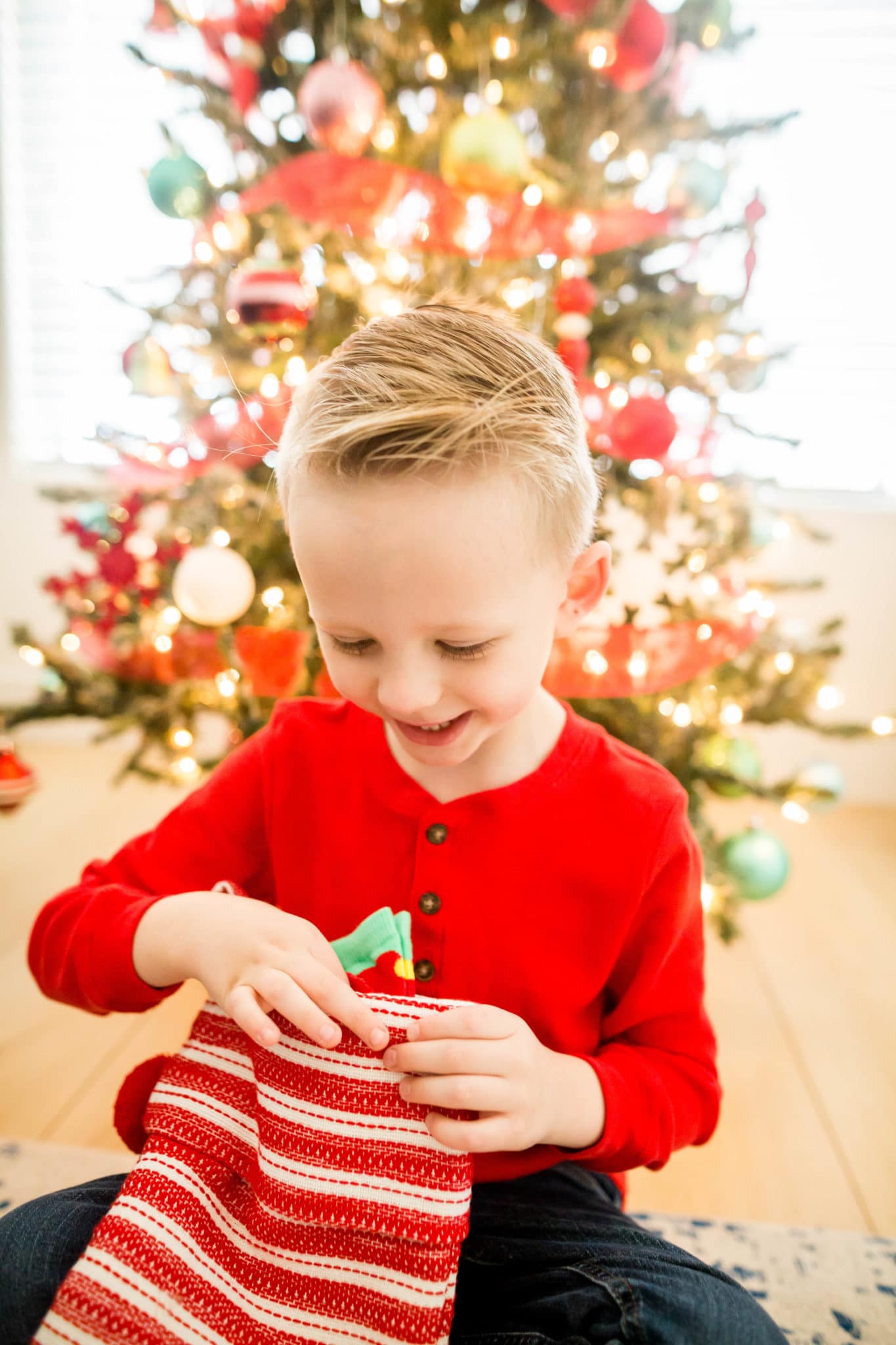 A kid opening their stocking finding Practical Stocking Stuffers for Kids. 