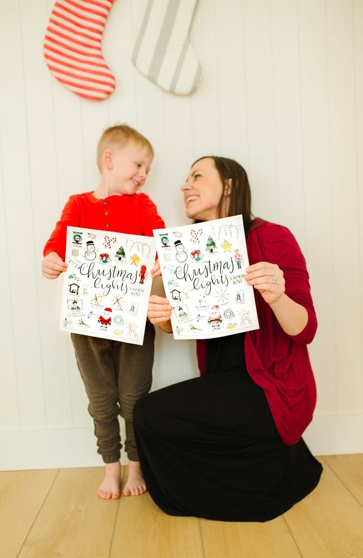 Family holding a Christmas Lights Scavenger Hunt printable game. 