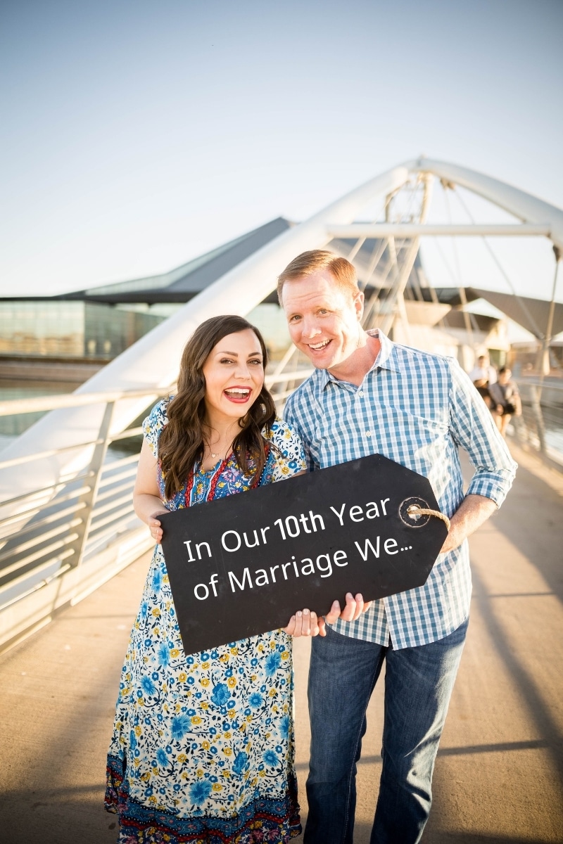 Highlights of the 10th year of marriage couple holding a sign. 