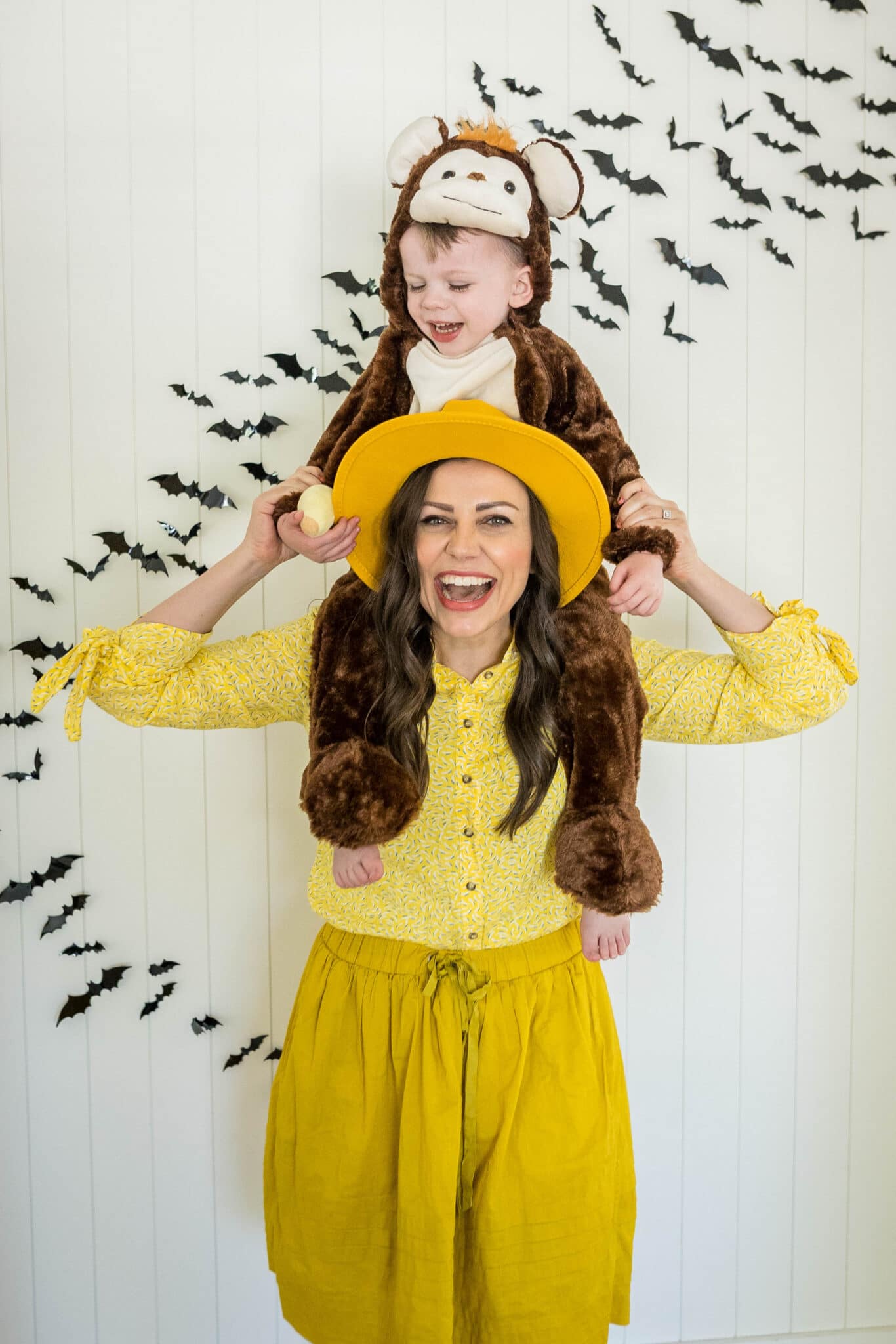 Mommy and Me Halloween Costume Ideas with mom dressed as man in the yellow hat and toddler dressed as Curious George. 