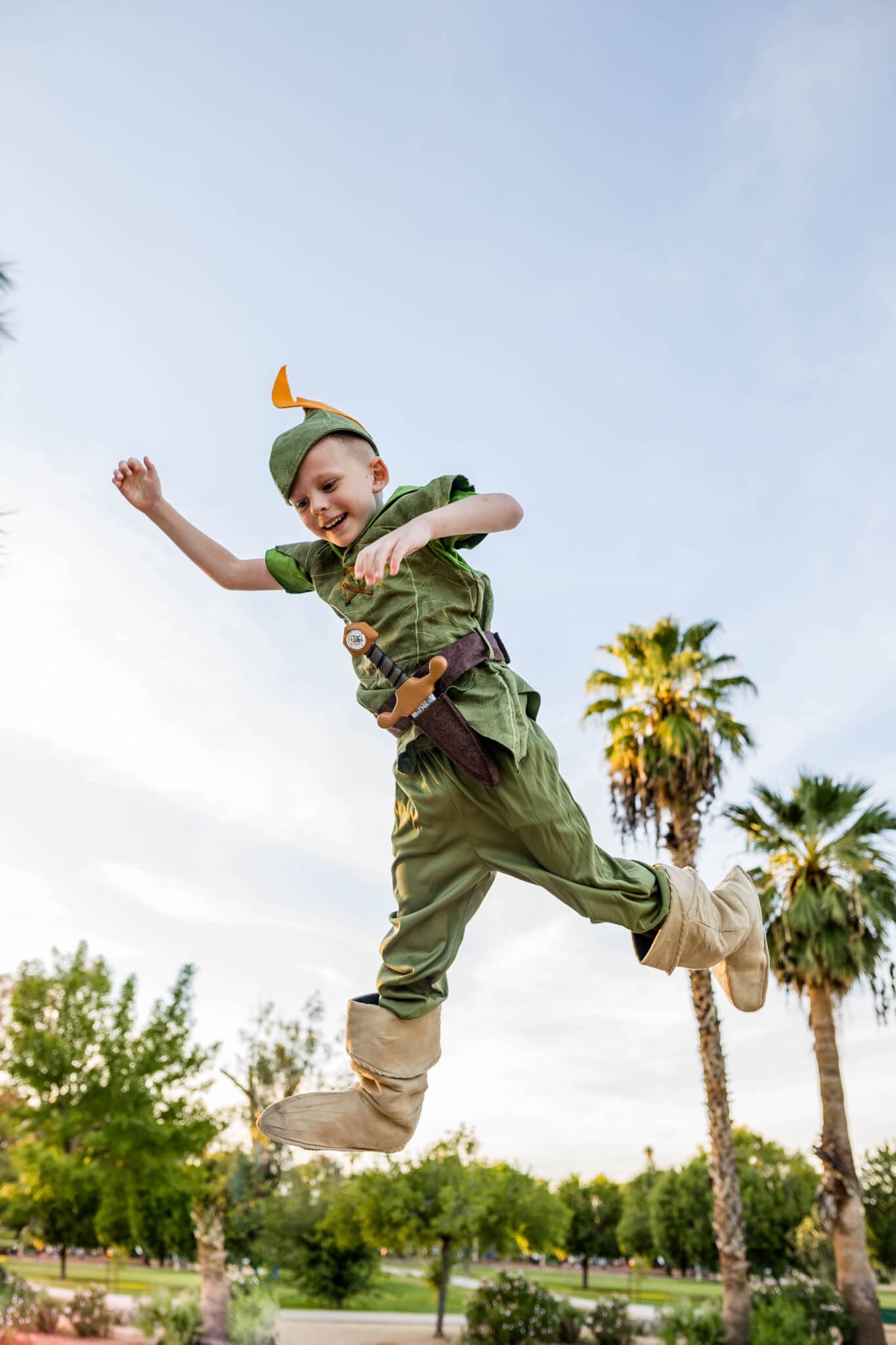  A boy thrown in the air to look like he's flying in a little Boy's Peter Pan Costume. 