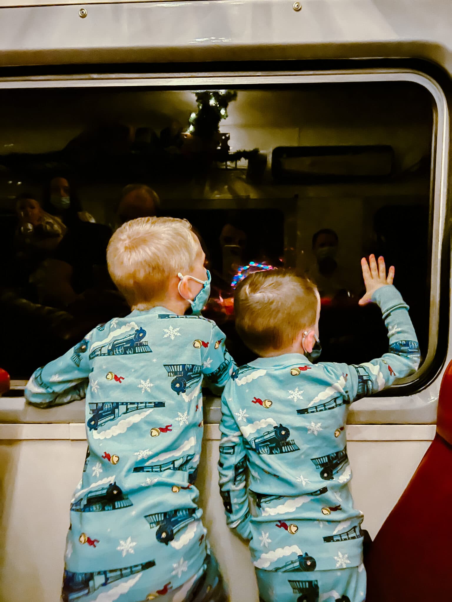 Kids wearing Polar Express Pajamas on a train. 