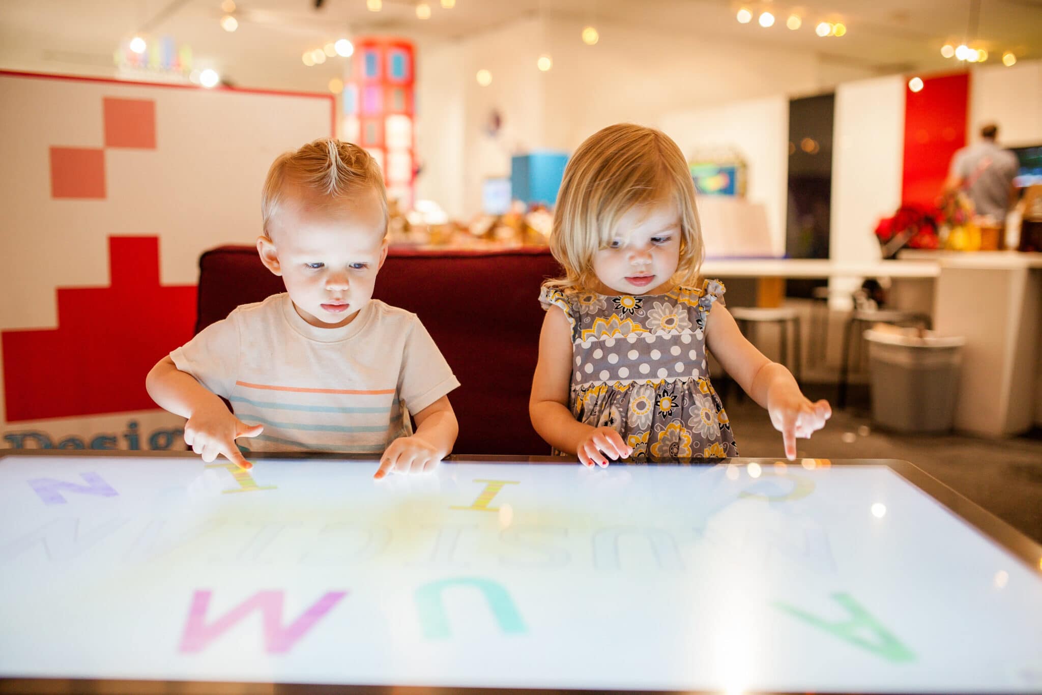 Two small children playing and using their Children's Museum Pass. 