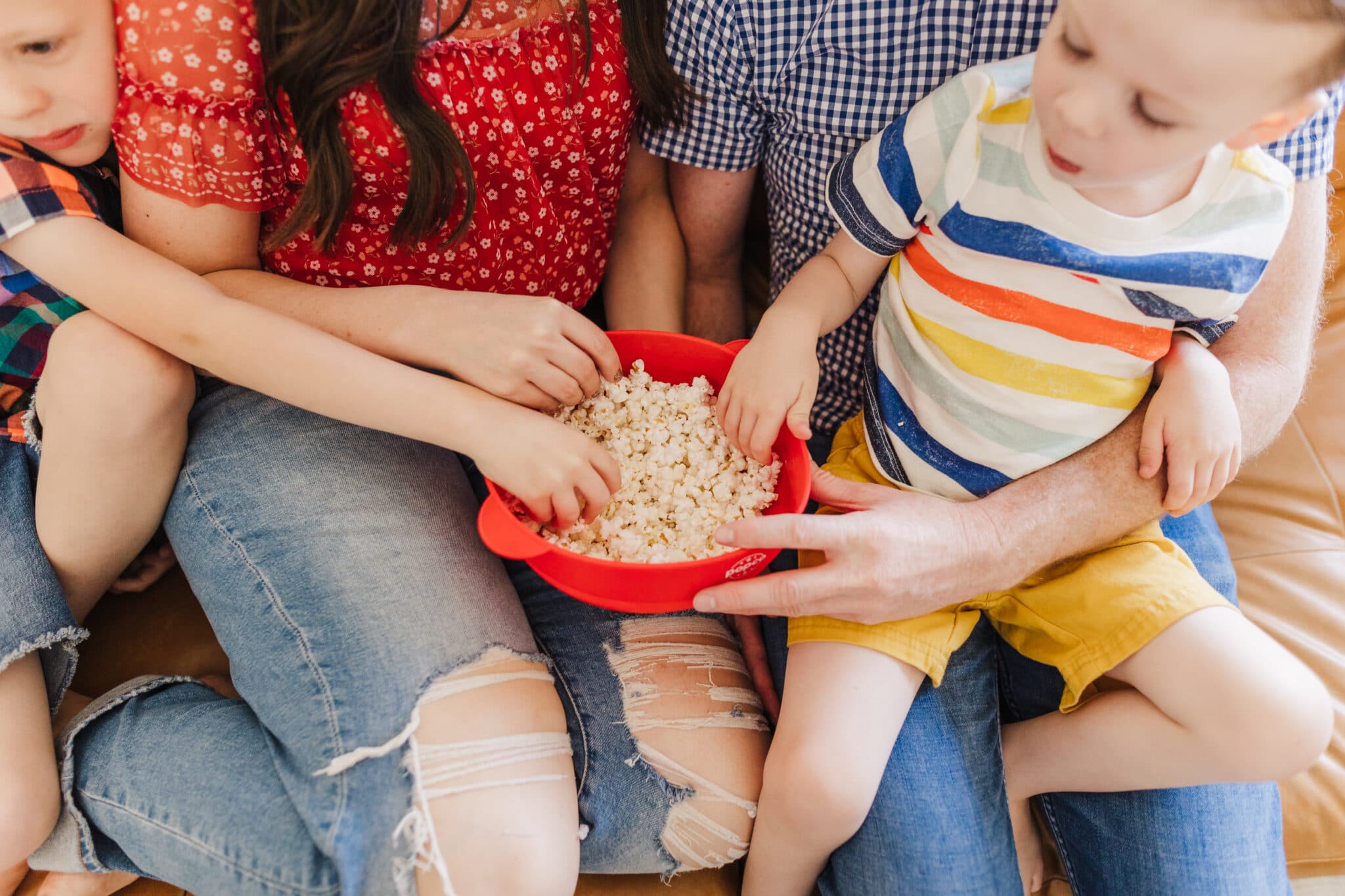 Family eating popcorn ready to enjoy a weekly Movie Day Tradition. 
