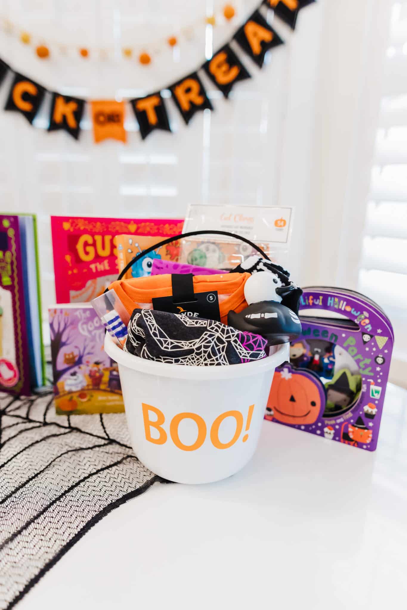 Table with Halloween pail and gift items for Spooky Basket Ideas. 