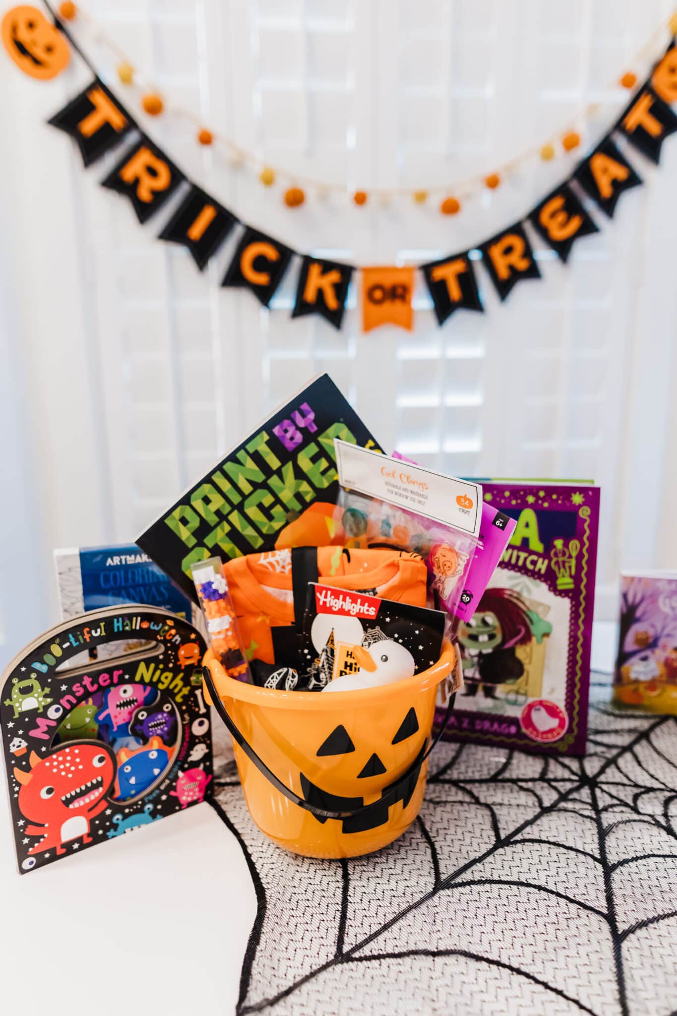 Halloween Spooky Basket set up on a table with Halloween goodie basket items inside. 