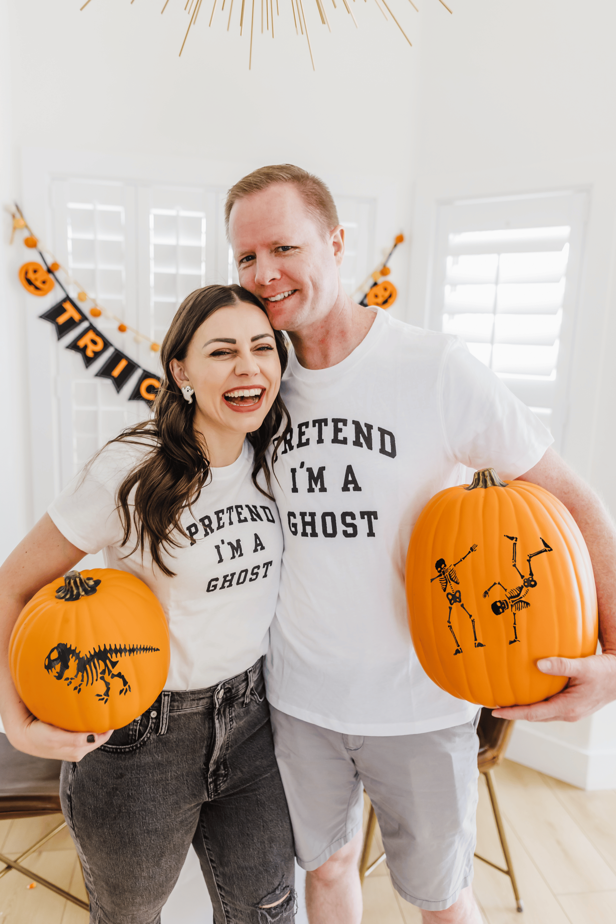 Pumpkin Painting Ideas with a couple holding two freshly painted pumpkins. 