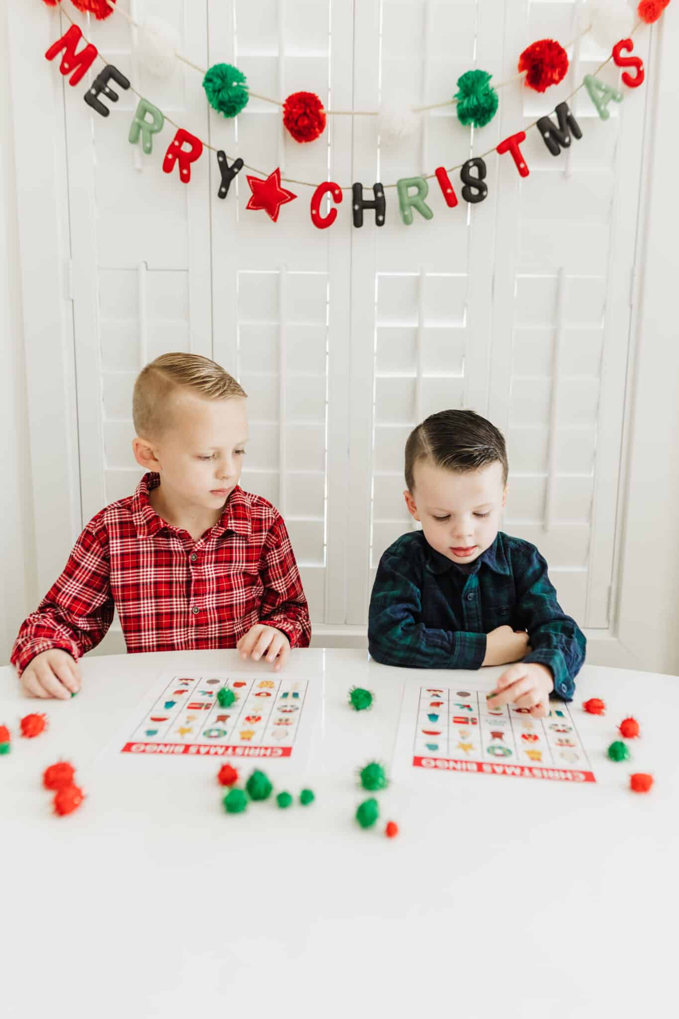 Christmas BINGO cards being used for a holiday BINGO game by two kids.