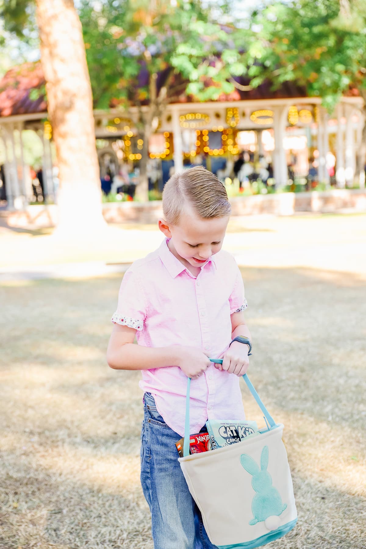 A boy showing an Easter basket full of Easter basket ideas for kids. 