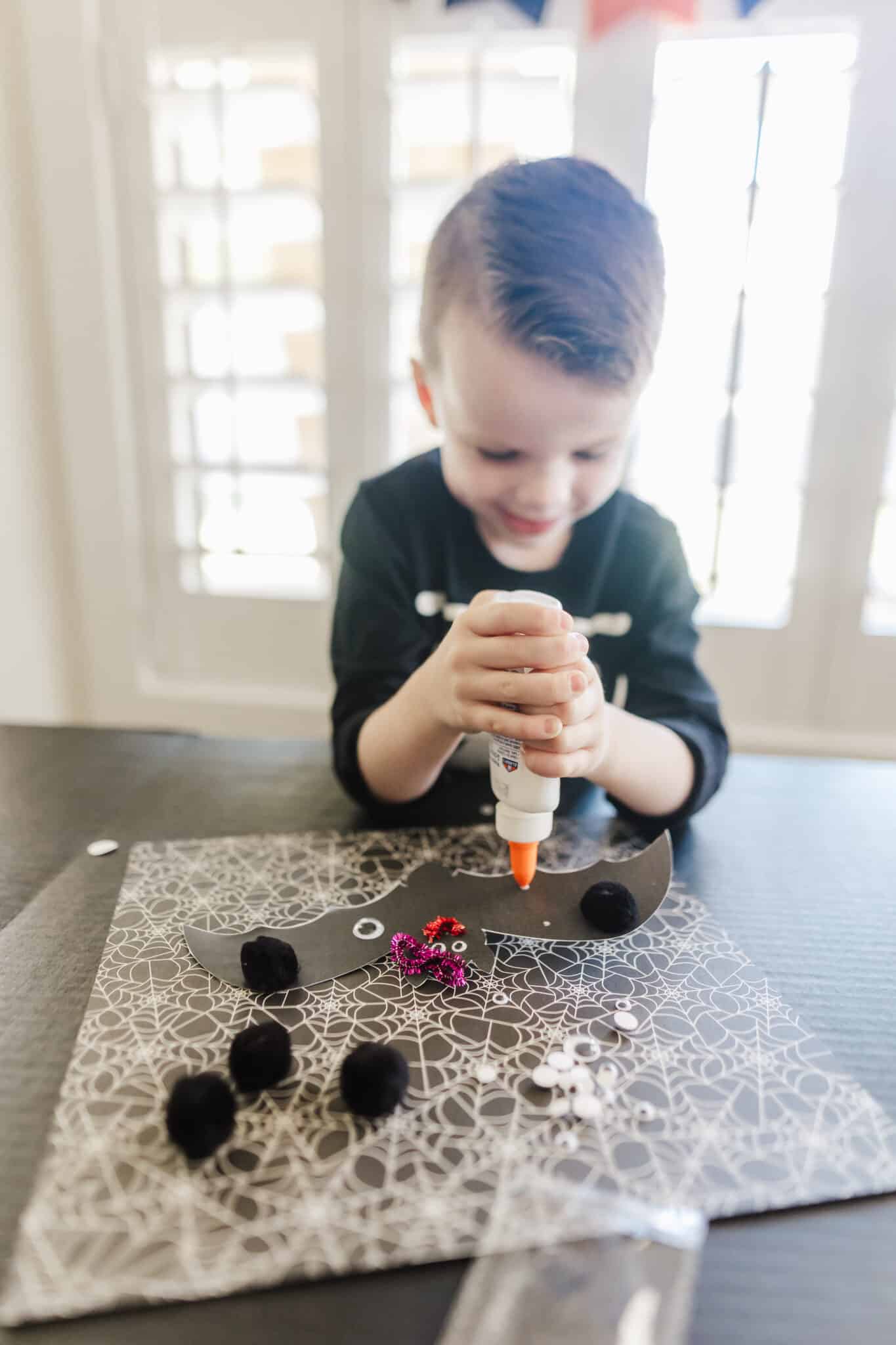 Preschooler using a Bat Template printable for Halloween crafts. 