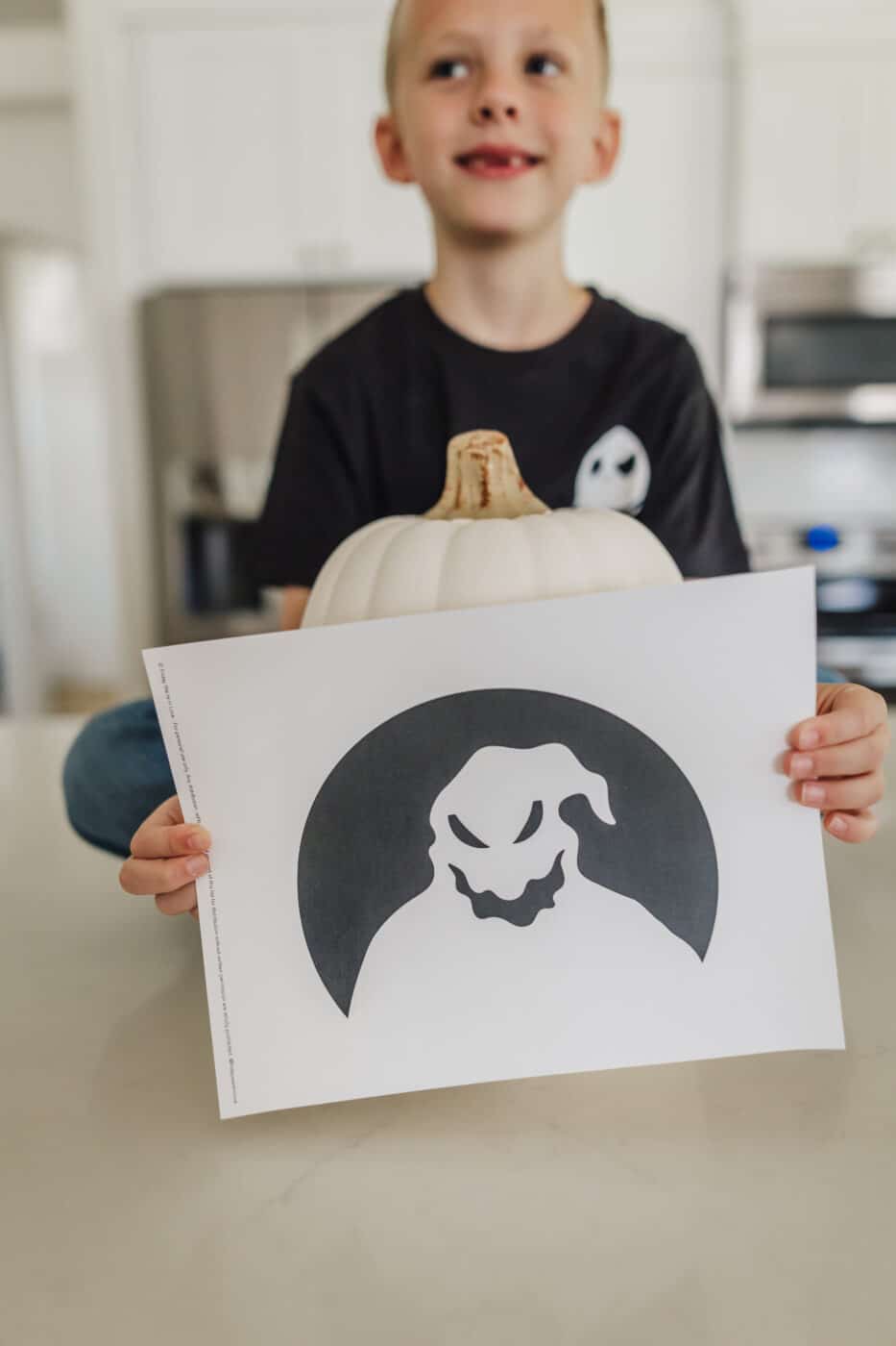 Oogie Boogie carving template print out in front of an un-carved pumpkin. 