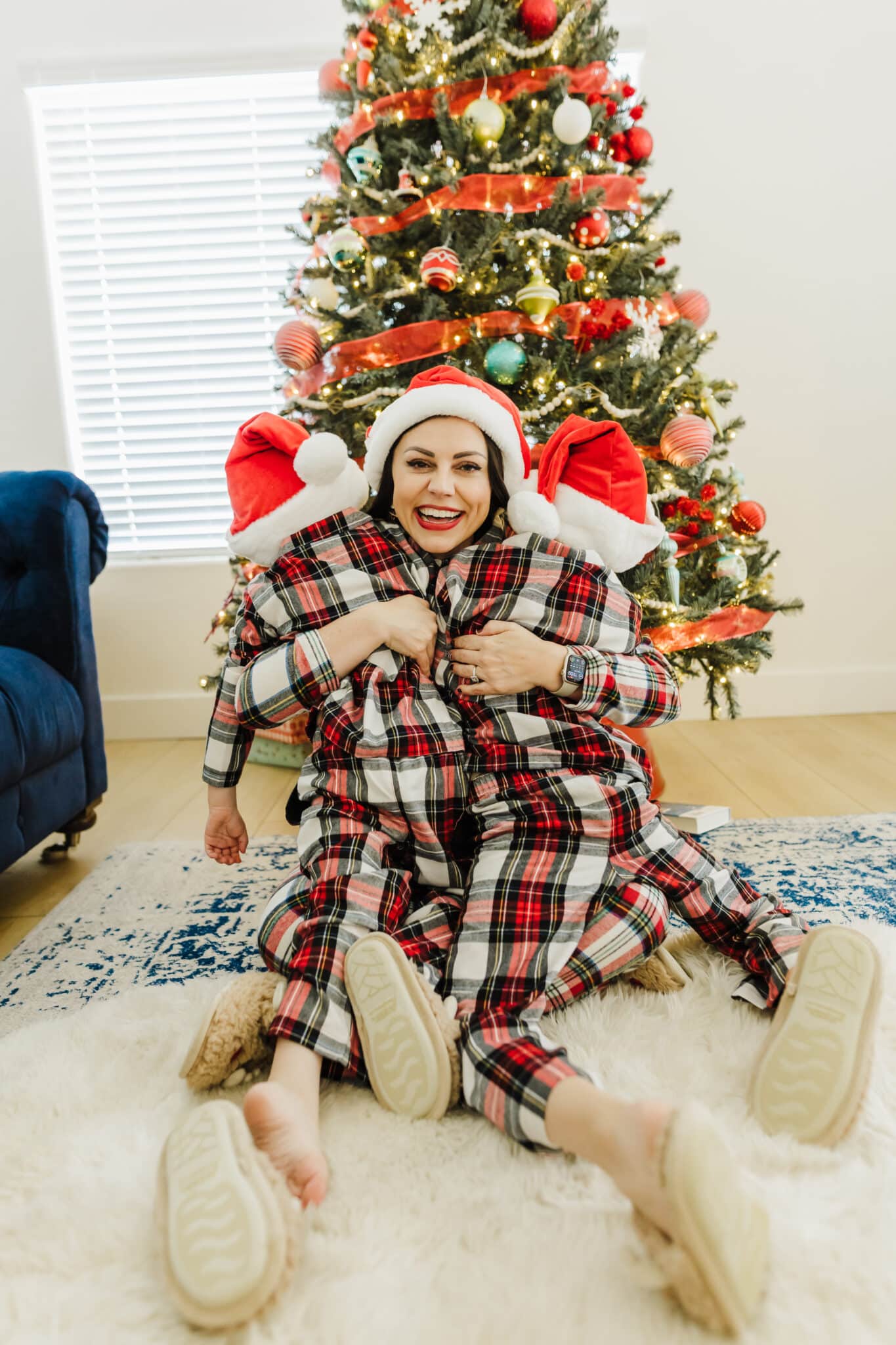 Christmas morning in pajamas picture idea hugging kids in front of the Christmas tree. 