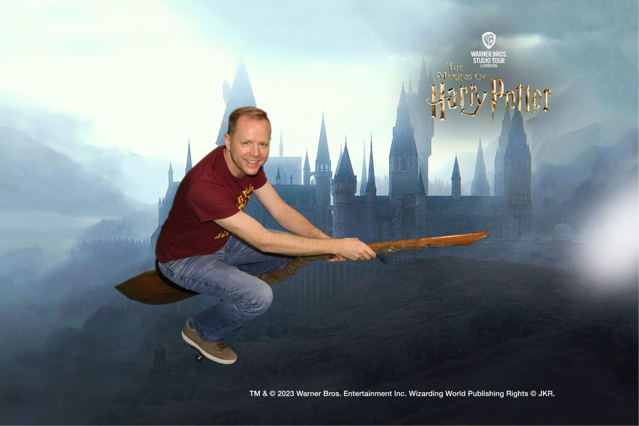 A photo download from the green screen experience at The Making of Harry Potter studio tour with a man on a broom flying in front of Hogwarts. 