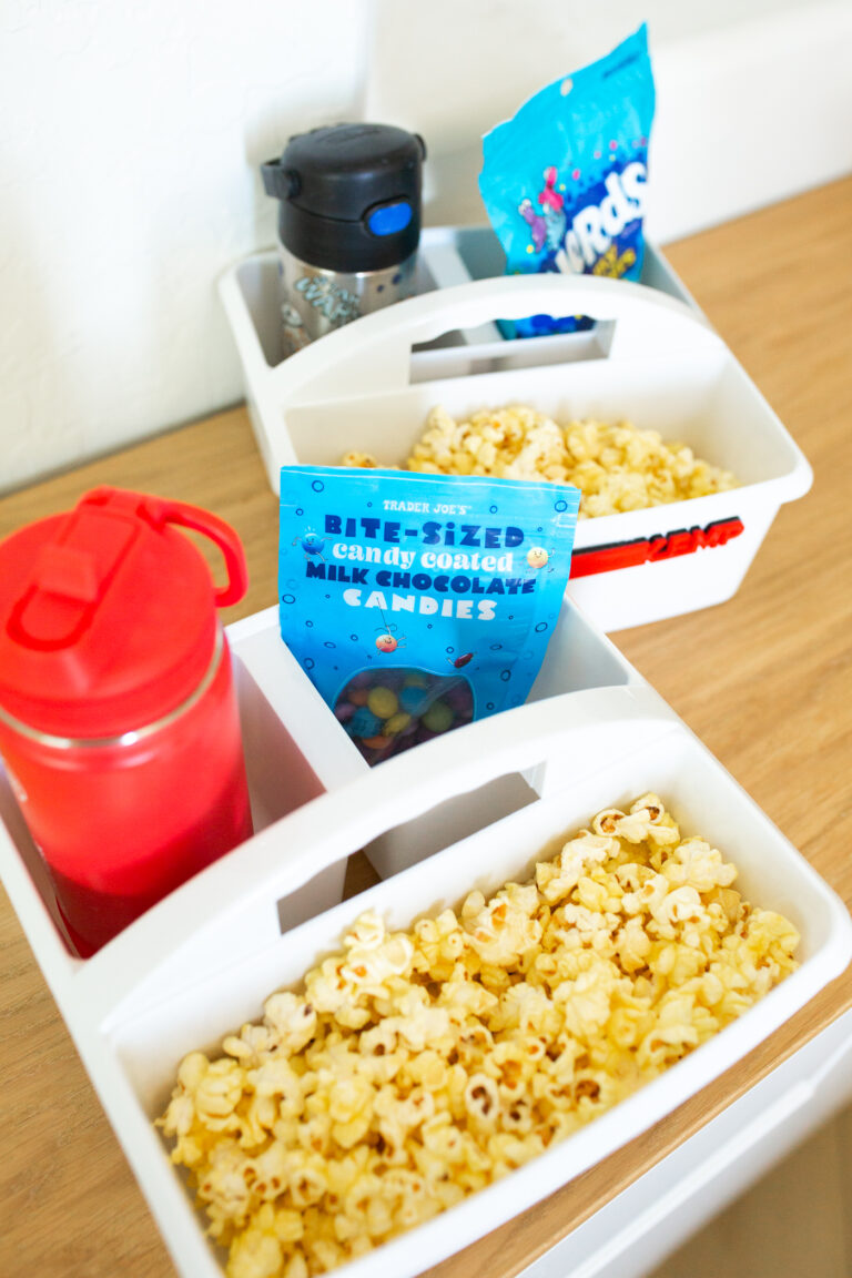 Movie night snack tray caddy filled with popcorn and movie snacks.