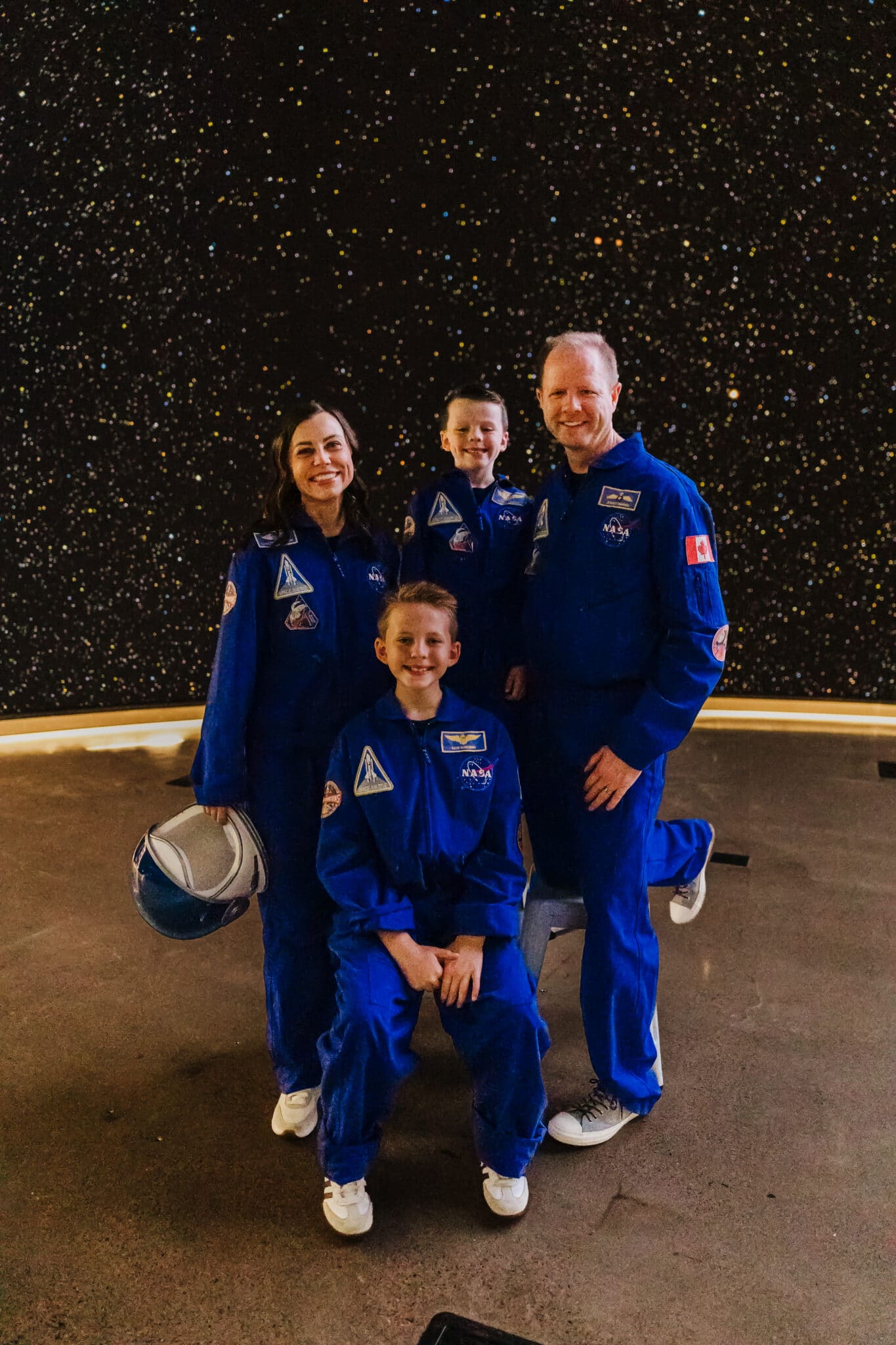 Astronaut family costume with family dressed in blue flight suits as the crew of the NASA Artemis II space mission.