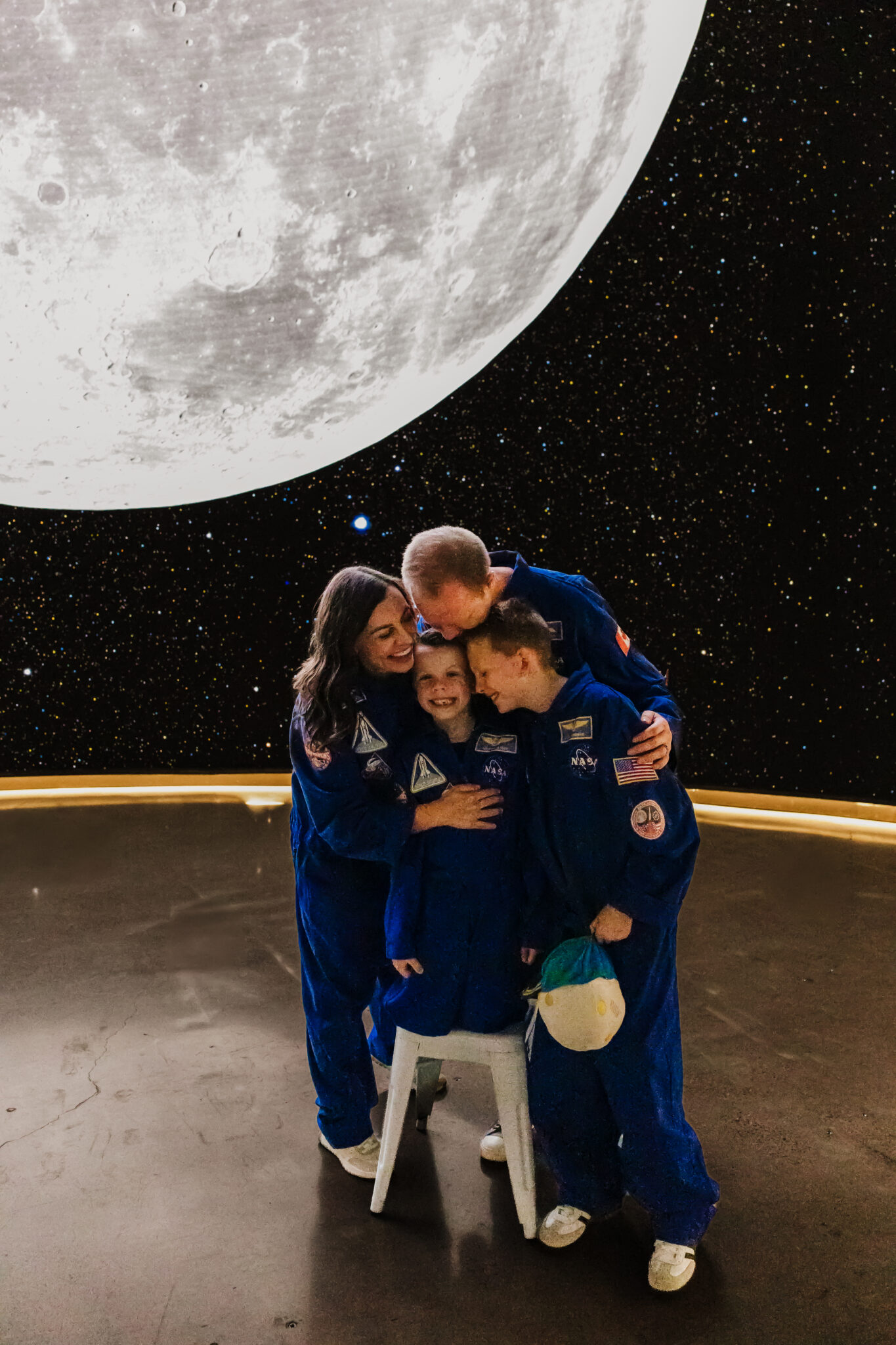 Family in Artemis II space crew costumes recreating their iconic hug picture