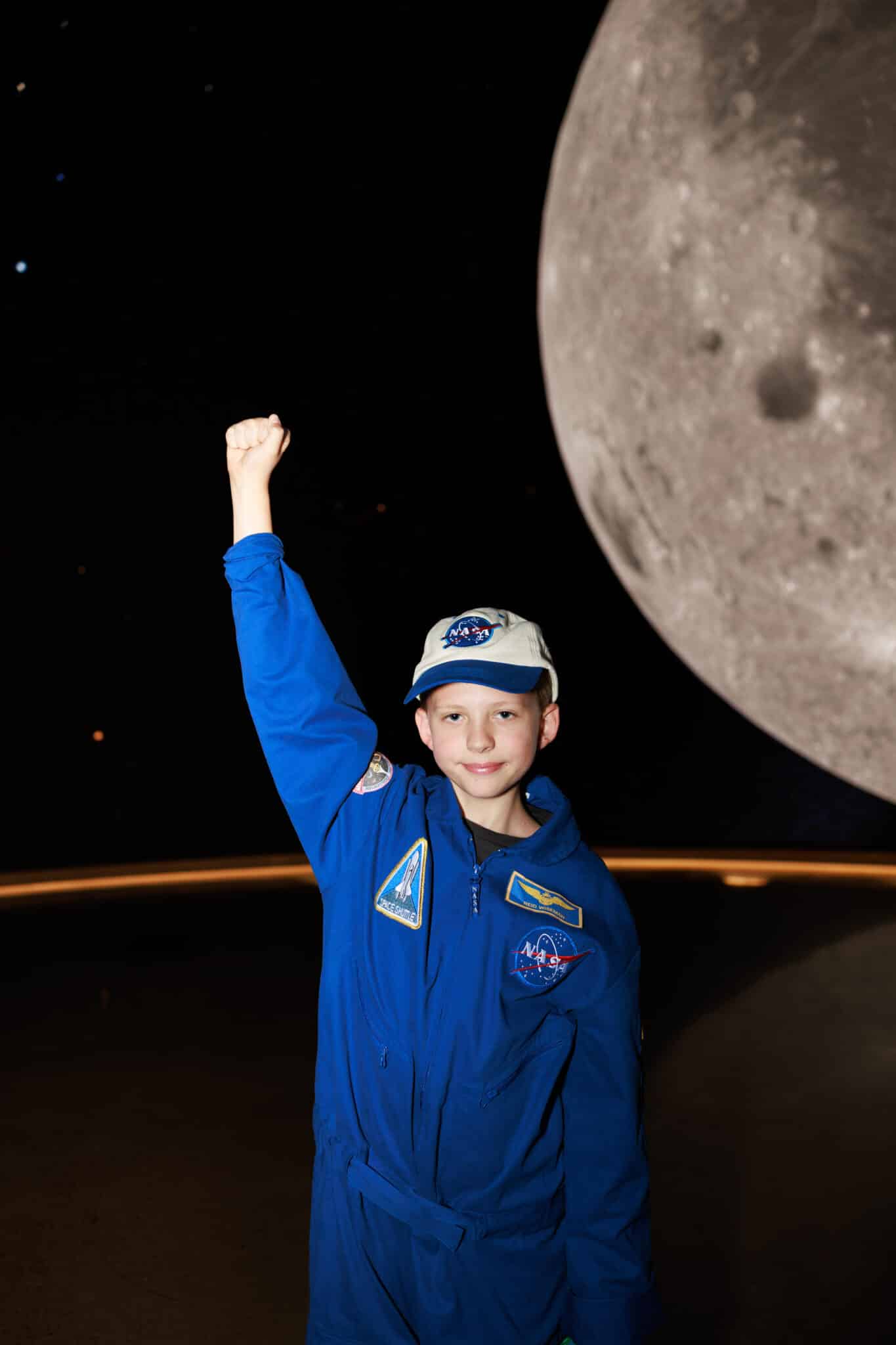 Reid Wiseman Halloween costume with a kid in a NASA costume in front of a moon backdrop